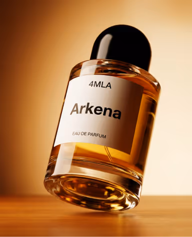 Крупный план наклоненного флакона духов с этикеткой '4MLA Arkena Eau De Parfum' и янтарной жидкостью внутри на теплом фоне.
